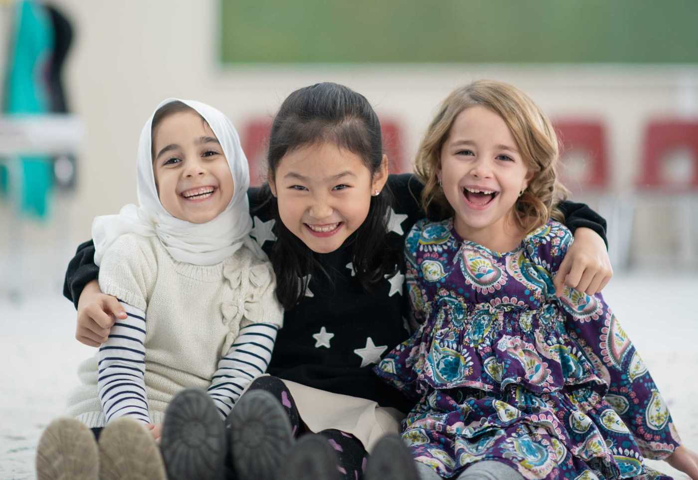 Three school friends having a hug and a laugh