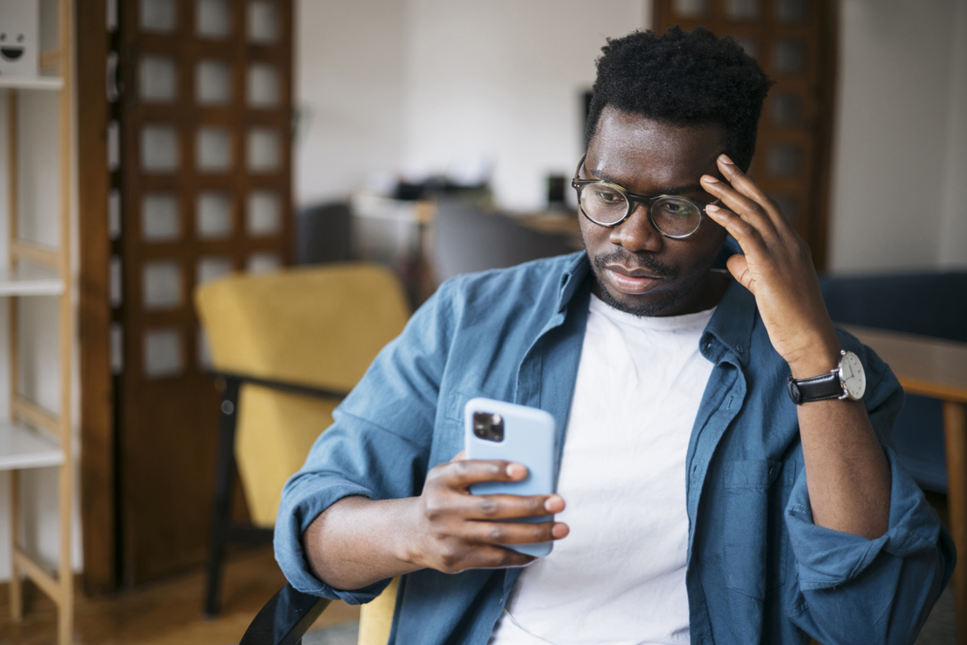 Man looking concerned about something he's reading on his phone