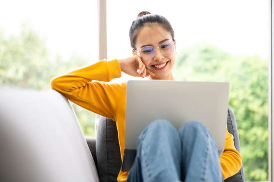 Image of a young girl smiling at a laptop