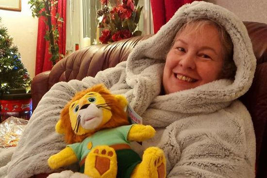 A woman cuddles a plush toy lion
